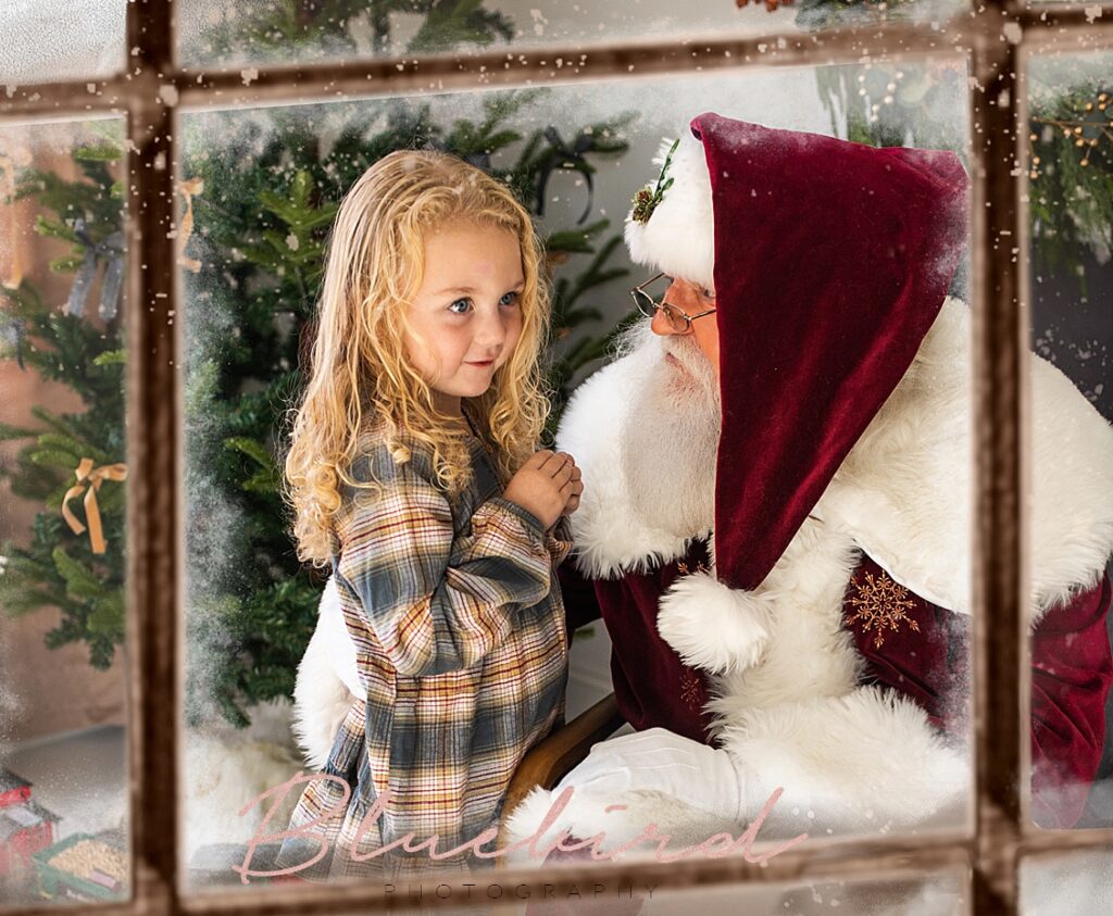Girl sits on Santa's lap in Leo Indiana as seen through a window