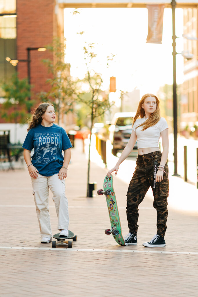 a group of high school girls pose with skateboards during a photoshoot in downtown fort wayne
