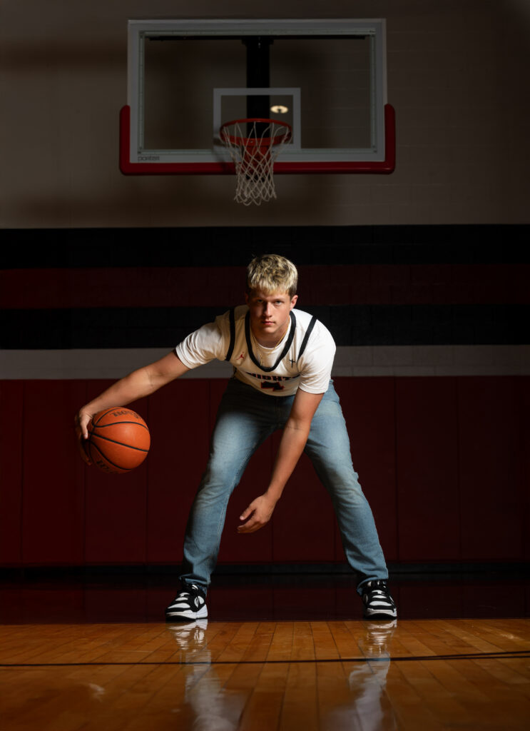 Senior wearing a basketball jersey with jeans, adding a stylish twist to traditional sports photography.