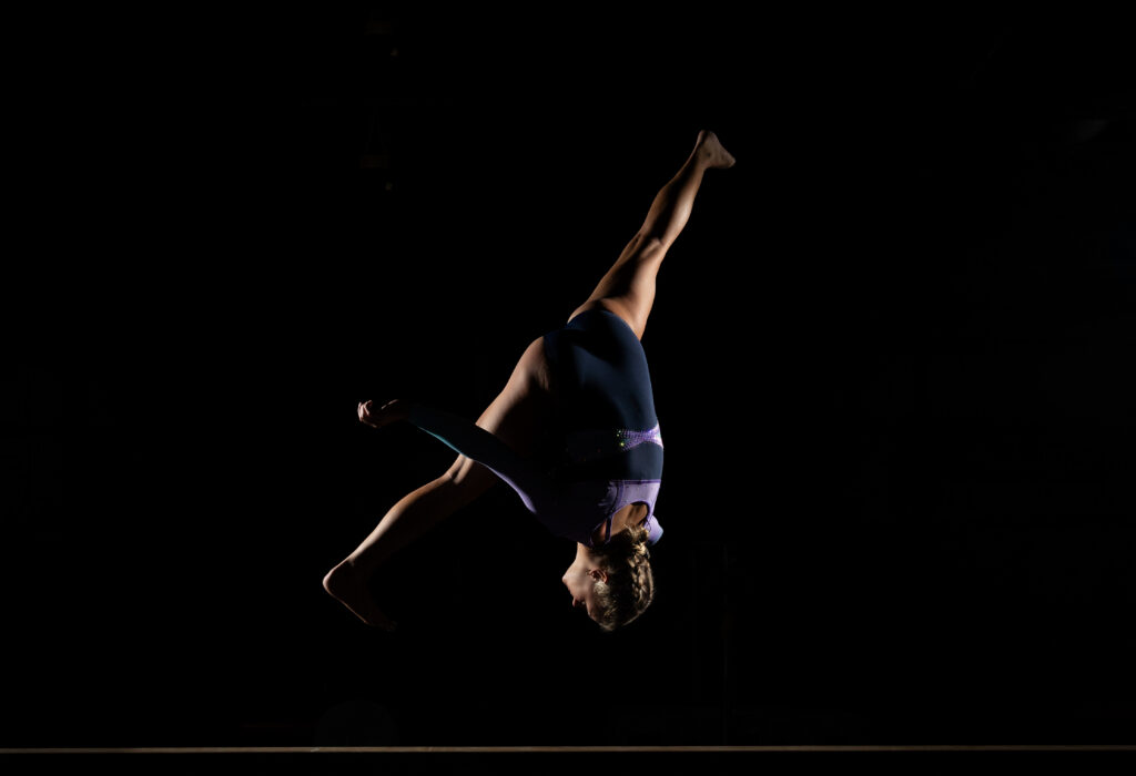 Senior gymnast performing on beam at Summit Academy gym in Fort Wayne, capturing her athleticism and energy.