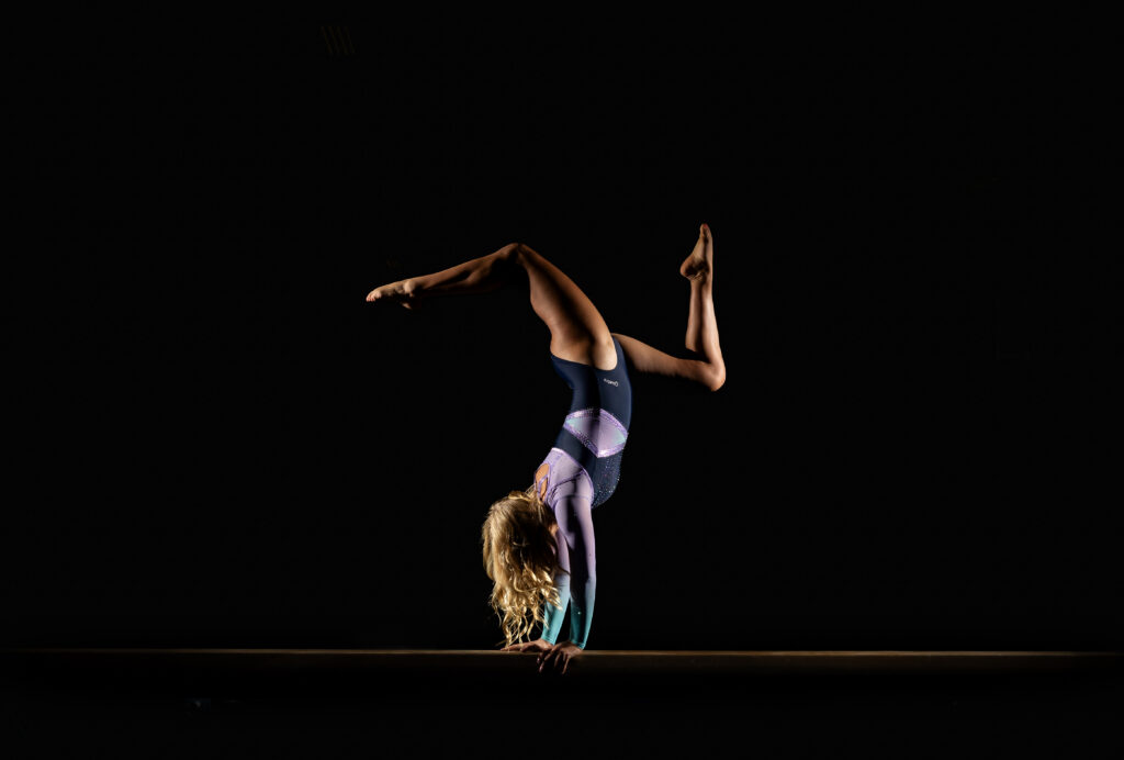 Senior gymnast posing with movement Summit Academy gym in Fort Wayne, capturing her athleticism and energy.